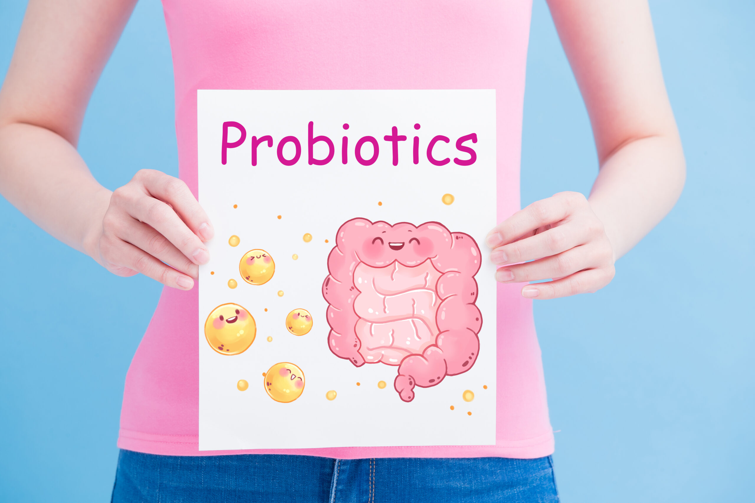 Person holding a sign that says “Probiotics” with an image of a digestive system on it.